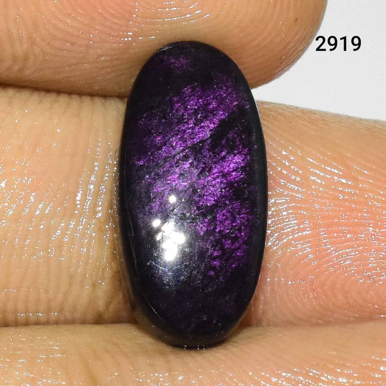 Puede incluir: Una piedra preciosa ovalada de color p&uacute;rpura oscuro con brillo iridiscente. La piedra preciosa est&aacute; engastada en un anillo de plata.