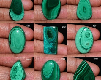 Puede incluir: Nueve cabochones de malaquita verde en varias formas y tamaños, incluyendo ovalado, lágrima y rectangular. Las piedras tienen un patrón de remolino de verde y negro.