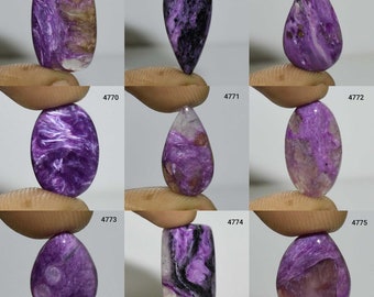 May include: A collection of ten purple and white gemstone cabochons, each with a unique pattern and shape. The cabochons are arranged in a grid of three rows and four columns. The cabochons are all approximately 2.5 cm in size.