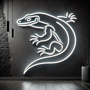 Può includere: Un cartello al neon bianco di una lucertola con la coda arricciata, montato su una parete grigio scuro.