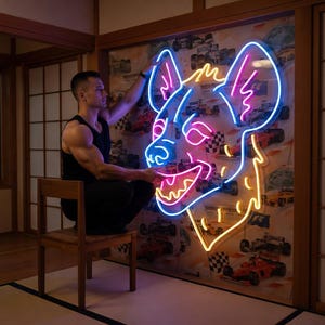May include: A neon sign in the shape of a hyena's head, outlined in blue, pink, and yellow. The sign is mounted on a wall with a racing car design. A person is sitting on a wooden chair, interacting with the sign.