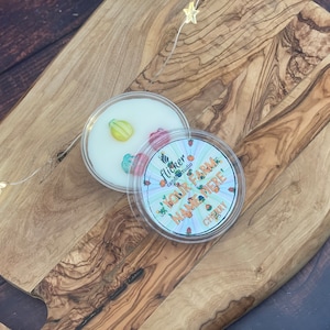 Puede incluir: Un recipiente de plástico transparente con una fusión de cera blanca en su interior. La fusión de cera tiene un diseño colorido con el texto "Our Farm Name Here!" y "Cherry" impreso en él.