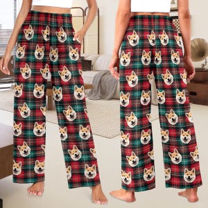 May include: Red and green plaid pyjama trousers with a repeated pattern of a dog's face. The trousers have a wide leg and an elastic waistband.