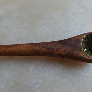 May include: A wooden spoon with a green glitter filled bowl.