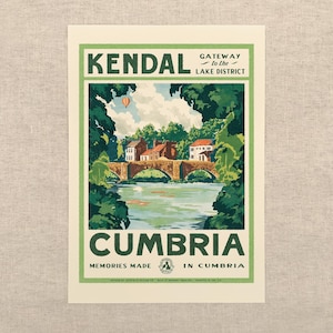 May include: A rectangular travel poster print featuring a stone bridge over a river in Kendal, Cumbria. The illustration includes green trees, buildings, and a hot air balloon in the sky. Text reads: KENDAL GATEWAY to the LAKE DISTRICT CUMBRIA.