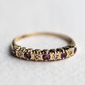 Peut inclure: Une bague en or avec une rangée de pierres précieuses violettes et transparentes alternées.