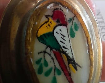 Vintage oval brass pill box with bird design hand painted on shell lid.