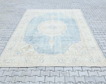 Könnte beinhalten: Ein Vintage-Teppich mit einem hellblauen Zentrum und einem cremefarbenen Rand. Der Teppich hat ein Blumenmuster und ein zentrales Medaillon.