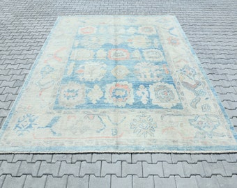 Könnte beinhalten: Ein Vintage-Teppich in Blau- und Cremetönen. Der Teppich hat ein florales Muster mit filigranen Details.