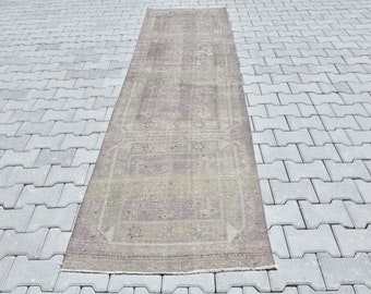 May include: A vintage runner rug with a faded floral pattern in shades of pink, green, and beige. The rug is laid out on a gray concrete patio.