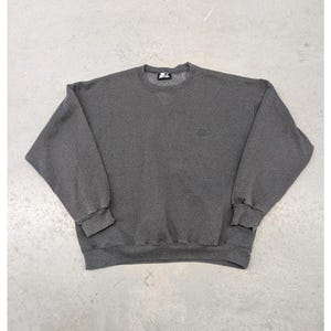May include: A dark grey sweatshirt with a crew neck and long sleeves. The Starter logo is visible on the upper left chest. The sweatshirt is made of a soft, comfortable material.