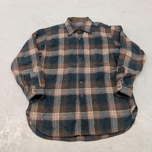 Puede incluir: Una camisa de manga larga con botones y un patrón de cuadros en tonos marrón oscuro, gris carbón y beige. La camisa presenta un cuello puntiagudo, un bolsillo en el pecho en el lado izquierdo y un dobladillo curvo con tapeta frontal.