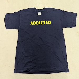 May include: A navy blue t-shirt with the word "ADDICTED" printed in yellow on the front.