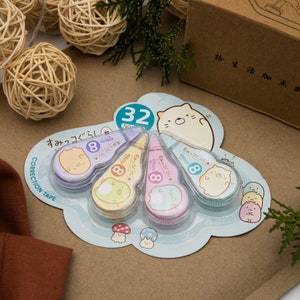 Peut inclure: Un ensemble de quatre correcteurs de ruban adhésif avec de mignons personnages de dessins animés. Chaque distributeur est étiqueté avec le numéro 8 et le texte "すみっコぐらし".