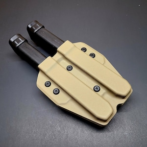 May include: Tan-colored double magazine pouch with two black magazines inserted. The pouch has multiple black screws securing the magazine holders.