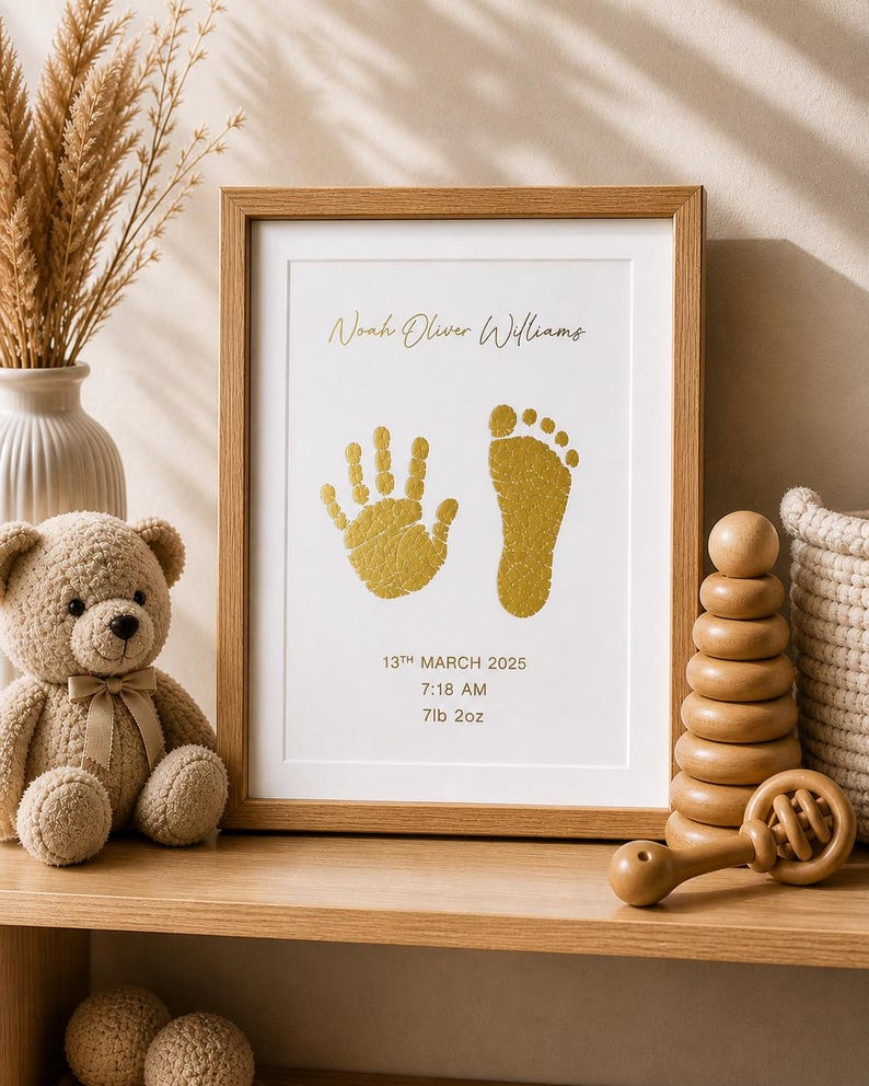 May include: A framed print with a baby's handprint and footprint in gold ink. The print includes the baby's name, date, time, and weight: 7lb 2oz. A teddy bear, wooden toys, and a woven basket are on the shelf.