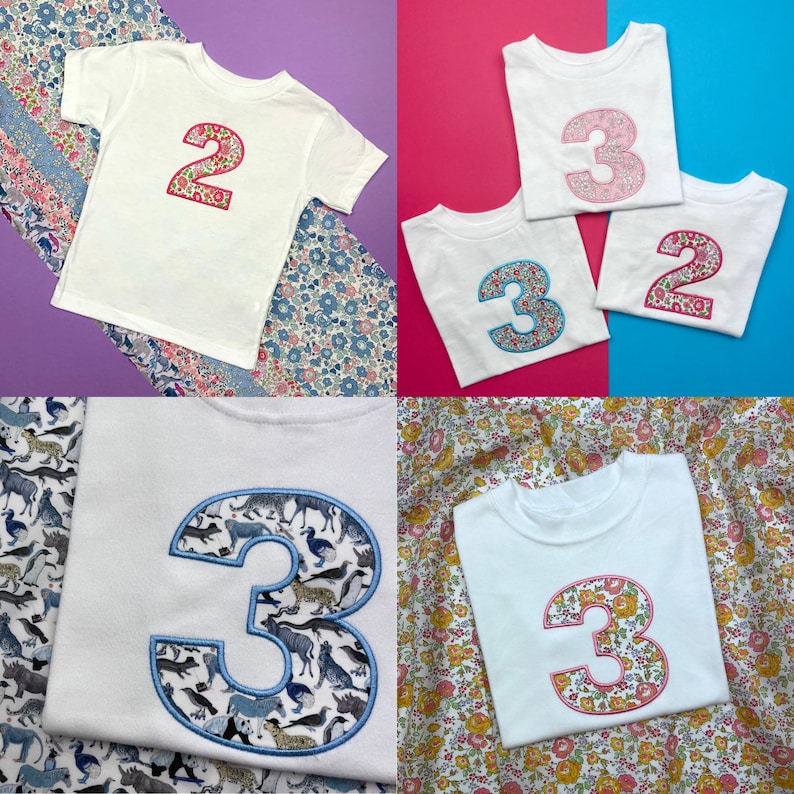 Puede incluir: Una colecci&oacute;n de camisetas blancas de manga corta con grandes n&uacute;meros aplicados en la parte delantera. Los n&uacute;meros est&aacute;n rellenos con varios patrones florales y de animales, incluyendo un n&uacute;mero 2 con flores rosas y un n&uacute;mero 3 con estampados de animales azules.