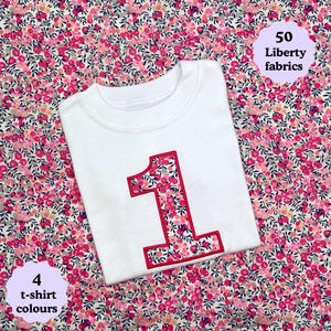 May include: A white t-shirt featuring a large number one appliqu&eacute; on the front. The number is filled with a pink, red, and white floral pattern and outlined in red stitching. Text on the image reads 50 Liberty fabrics and 4 t-shirt colours.