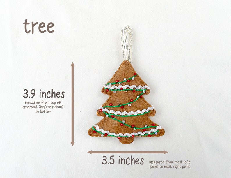 May include: A felt Christmas tree ornament in the shape of a tree with brown felt, white felt trim, red beads, and green felt garland. The ornament is 3.9 inches tall and 3.5 inches wide.