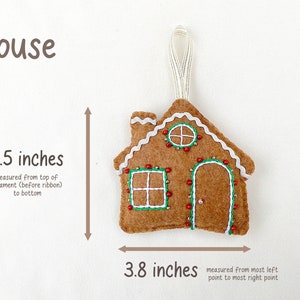 May include: A felt gingerbread house ornament with white icing, red bead lights, and green embroidery. The ornament is 3.5 inches tall and 3.8 inches wide.