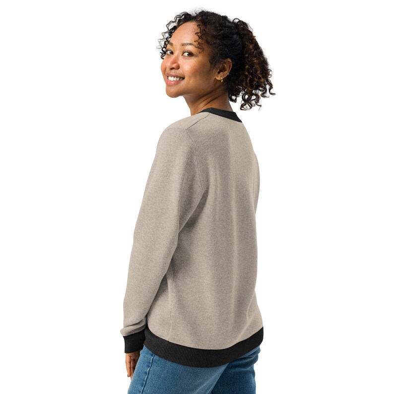 May include: A heather grey sweatshirt with black trim around the neck, cuffs, and hem. The sweatshirt is made of a soft, comfortable fabric.