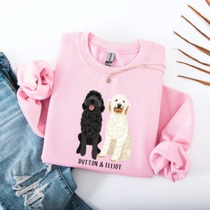 May include: Pink sweatshirt with a black and white dog illustration and the text "Dutton & Elliot".
