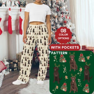 Pode incluir: Uma calça de pijama de cor creme com um padrão repetido de labradores marrons que usam chifres de rena e estão em pé na frente de árvores de Natal. A calça tem bolsos e está disponível em 8 cores. O padrão é mostrado em uma imagem quadrada menor.
