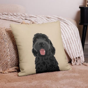 May include: A black and white illustration of a dog with a happy expression on a beige pillow. The dog has curly fur and is looking directly at the viewer.