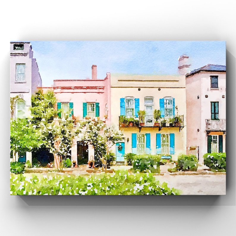 May include: A watercolor painting of a row of colorful houses with blue shutters and a lush green tree in front. The houses have white trim and are painted in shades of pink, yellow, and white.