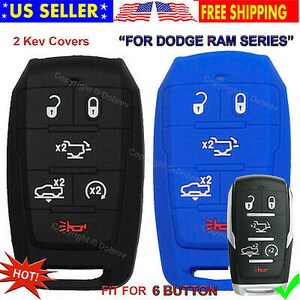 May include: Black and blue key fob covers for a Dodge Ram series vehicle. The covers have white icons for the buttons and are made of a flexible material. The image also shows a key fob.