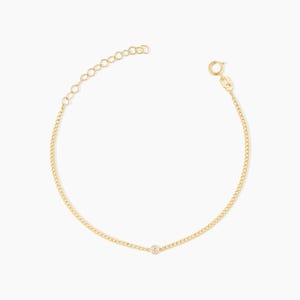 Könnte beinhalten: Ein zartes goldenes Armband mit einem kleinen, runden Diamanten in der Mitte. Das Armband hat ein Panzerketten-Design und eine verstellbare Länge. Der Verschluss ist ein kleiner Federring. Der Schmuck wird auf weißem Hintergrund präsentiert.