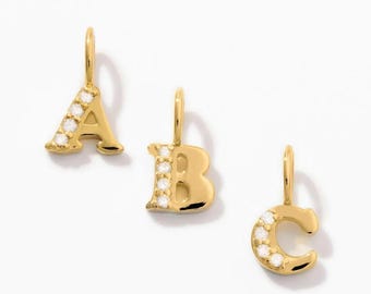 May include: Three gold-toned letter charms featuring the letters A, B, and C. Each charm is crafted with a polished gold finish and accented with a vertical row of small, clear, round-cut stones embedded along one side of the letter shape.