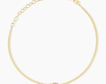 May include: A gold chain bracelet featuring two interlocking circular charms at the center. One circle is a plain polished gold band, while the other is a gold band encrusted with small clear stones. The bracelet includes a lobster claw clasp.