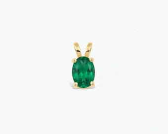 May include: A gold pendant featuring an oval-cut green gemstone held by four prongs. The setting is made of polished yellow gold, showcasing a classic design with a small bail at the top for attachment to a chain or necklace.