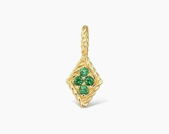May include: A gold pendant featuring a diamond-shaped frame with a twisted rope texture. The center of the pendant contains four small, round, vibrant green gemstones arranged in a cluster, topped with a matching twisted rope bail for hanging.