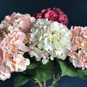 以下が含まれることがあります： ピンク、白、赤の紫陽花と緑の葉のブーケ