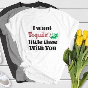 Puede incluir: Camiseta blanca con el texto "I want Tequila little time with you" en letras negras y rojas. Una rodaja de lima verde está al lado de la palabra "Tequila".