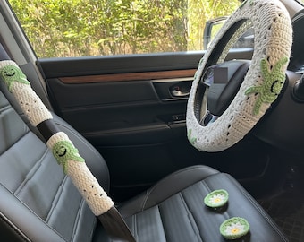 Peut inclure: Housse de volant en crochet blanc avec des fleurs brodées vertes. Deux housses de ceinture de sécurité assorties avec des smileys brodés verts.