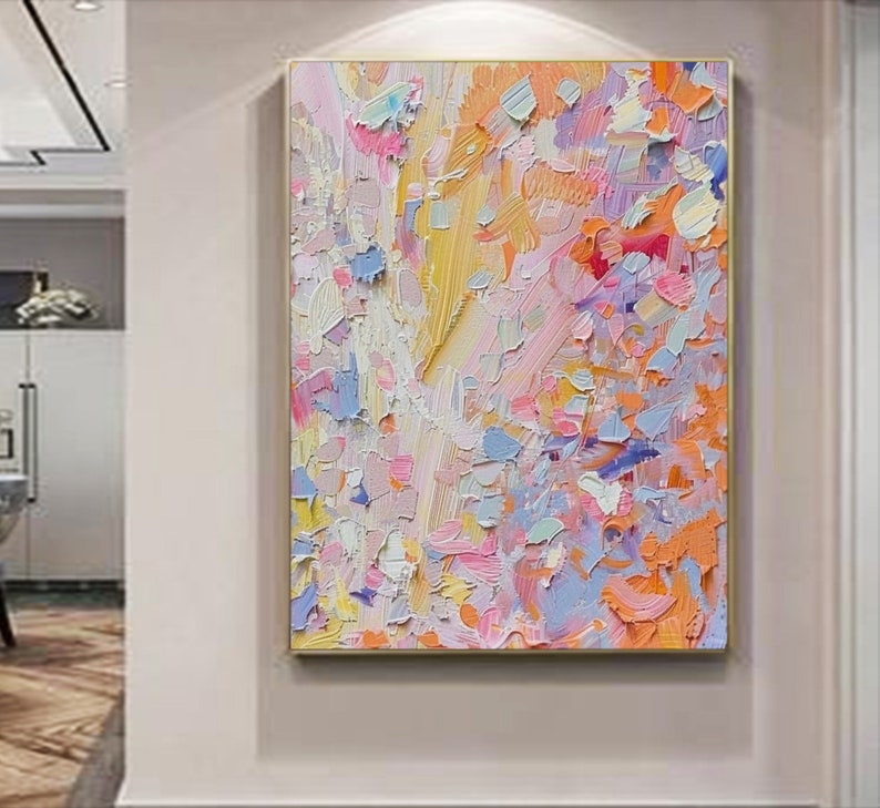 May include: Abstract oil painting with a gold frame. The artwork features a textured surface with a palette of pastel colors, including pink, blue, yellow, and orange. The brushstrokes create a dynamic and expressive composition.