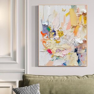 Op de afbeelding: Abstract schilderij met een witte achtergrond en kleurrijke penseelstreken in tinten roze, geel, blauw, groen en oranje.