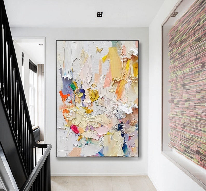 Op de afbeelding: Abstract schilderij met een witte achtergrond en kleurrijke penseelstreken in tinten roze, geel, blauw en groen. Het schilderij heeft een textuur en gelaagde uitstraling.
