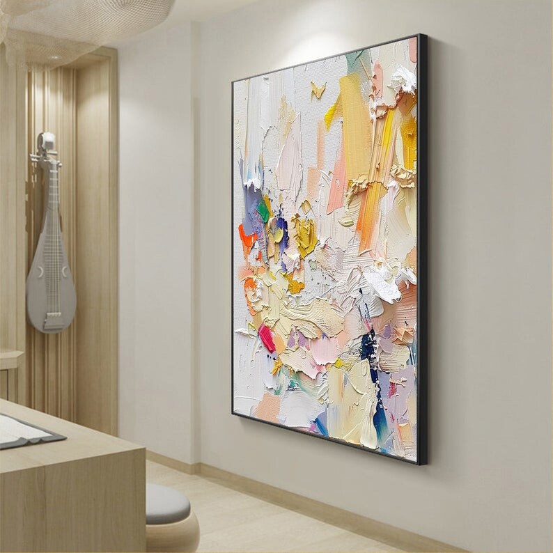Op de afbeelding: Abstract schilderij met een witte achtergrond en kleurrijke penseelstreken in tinten roze, geel, blauw, groen en rood. Het schilderij heeft een textuur en gelaagde uitstraling.
