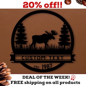 May include: Black metal moose silhouette with pine trees and grass inside a circle. The text "CUSTOM TEXT" and "EST. 1987" are below the circle. The background is brown.