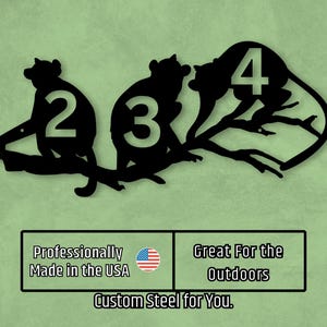 May include: Black metal house number sign with the numbers 2, 3, and 4. The numbers are displayed on a branch with stylized monkeys sitting on the branch. The sign is professionally made in the USA and is great for the outdoors.