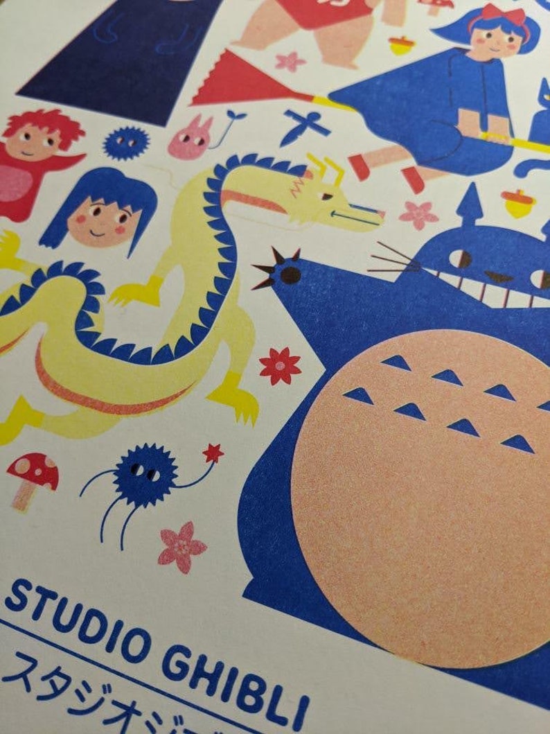 May include: A colorful illustration featuring characters from Studio Ghibli films, including Totoro, Kiki's Delivery Service, and Spirited Away. The illustration is printed on a white background and includes the text "Studio Ghibli" in black.