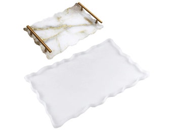 May include: Two white resin serving trays with gold accents. The top tray has a gold metallic finish and gold handles. The bottom tray is plain white.