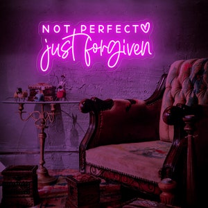 May include: Pink neon sign with the text "NOT PERFECT just forgiven" and a small heart symbol.