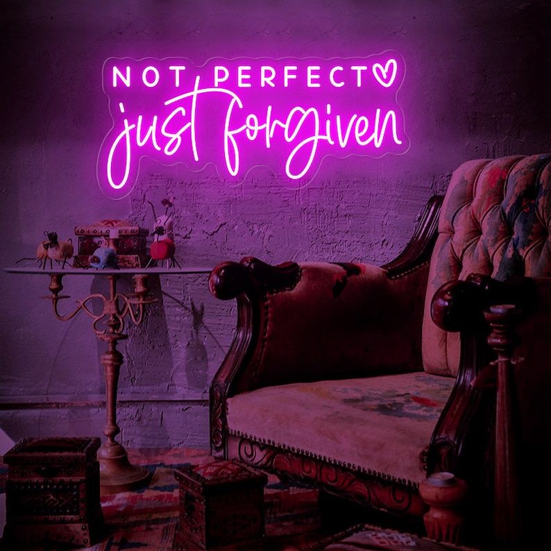 May include: Pink neon sign with the text "NOT PERFECT just forgiven" and a small heart symbol.