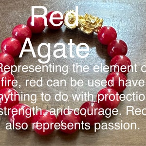 May include: Red agate bracelet with a gold dragon charm. The bracelet is made of round beads and is about 8 inches long. The text "Red Agate" is written in white letters on a red background. The text below reads "Representing the element of fire, red can be used have anything to do with protection, strength, and courage. Red also represents passion."