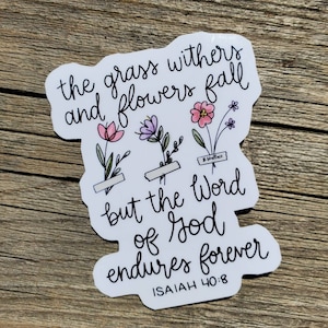 May include: White sticker with black calligraphy that reads "the grass withers and flowers fall but the Word of God endures forever ISAIAH 40:8". The sticker features a floral design with pink, purple, and green flowers.